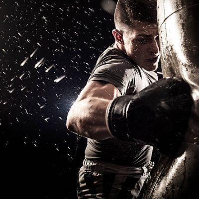 Young man boxing at the punching bag