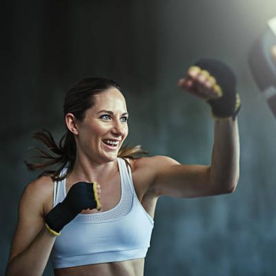 Shot of a young woman sparring with a boxing partner at the gym